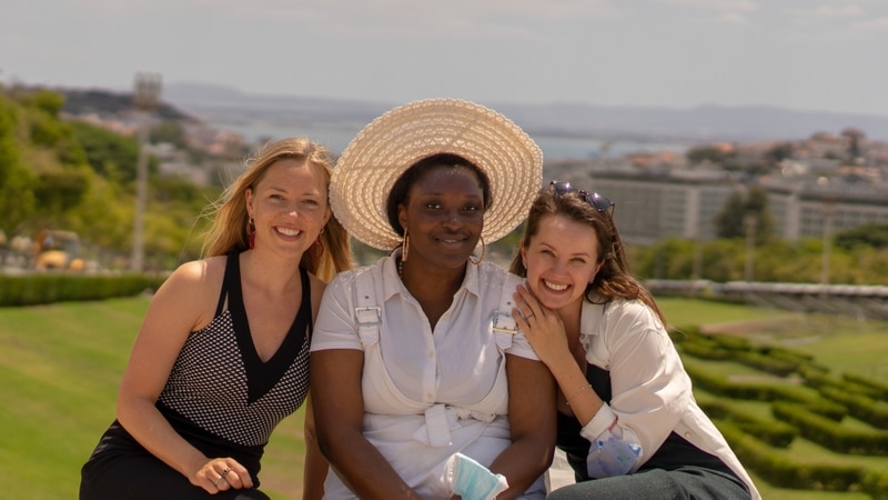 Bibi, Tracy and Kate sat closely smiling with a luscious green park in the background.