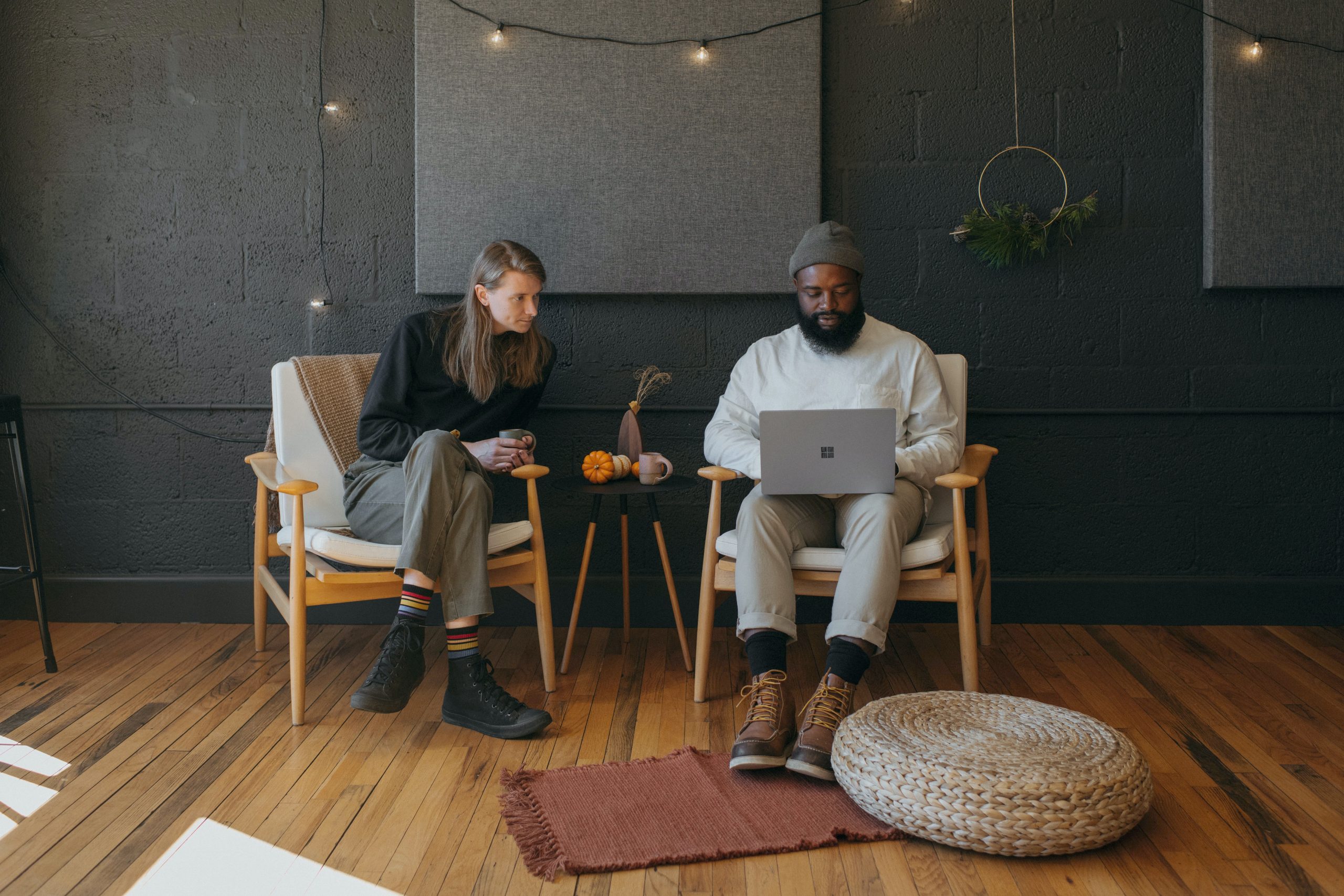 Two people at a mentoring meeting at work. They are both looking at a laptop together.